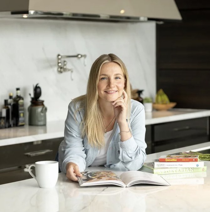 Allysa Solberg, Registered Dietitian, smiling at a kitchen counter with a recipe book open