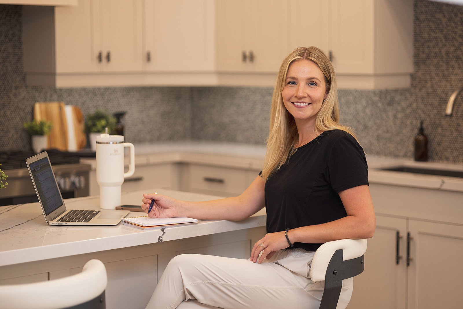 Allysa Solberg, Registered Dietitian, smiling at her kitchen counter with a laptop and notebook